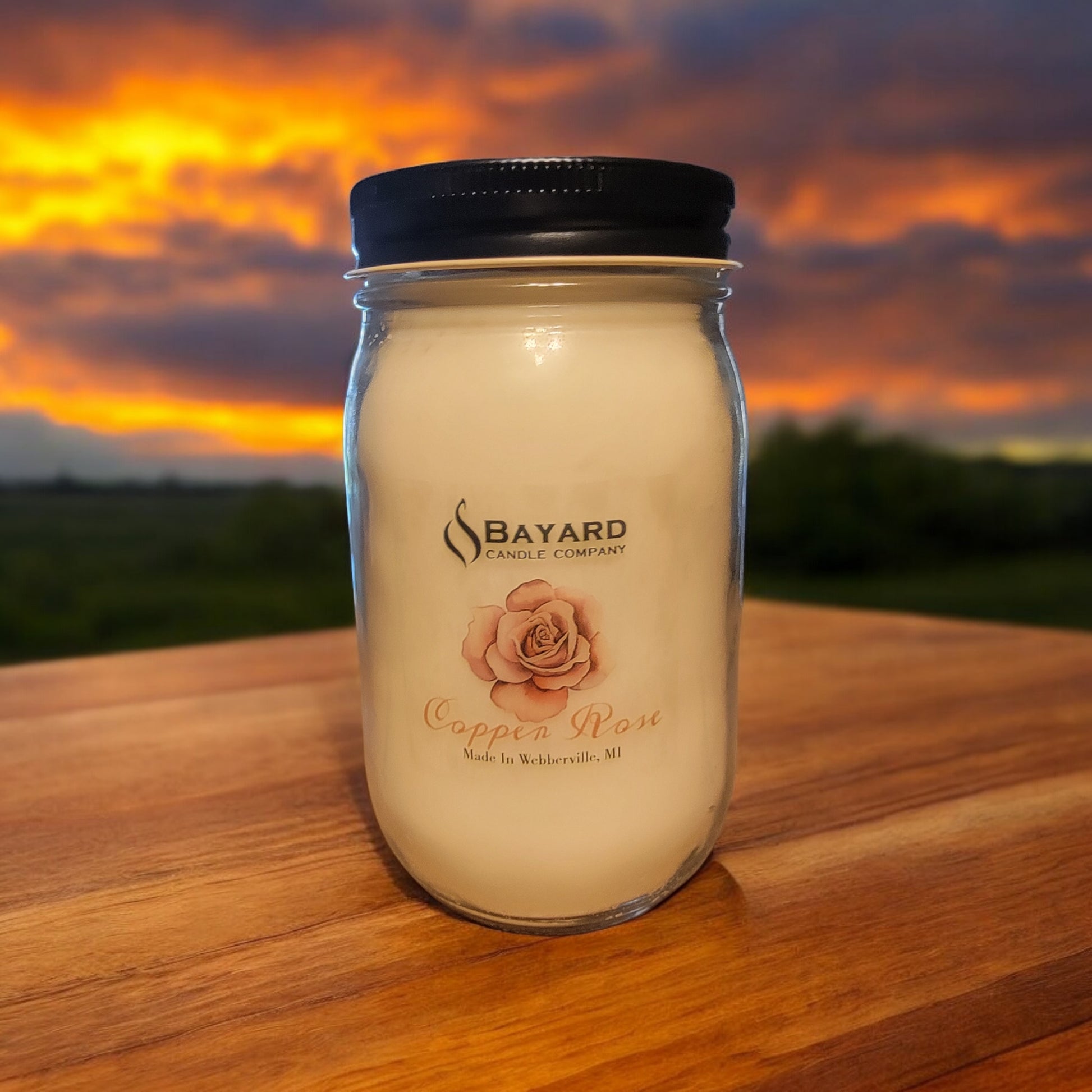 16oz Copper Rose Soy Candle with a beautiful sunset in the background