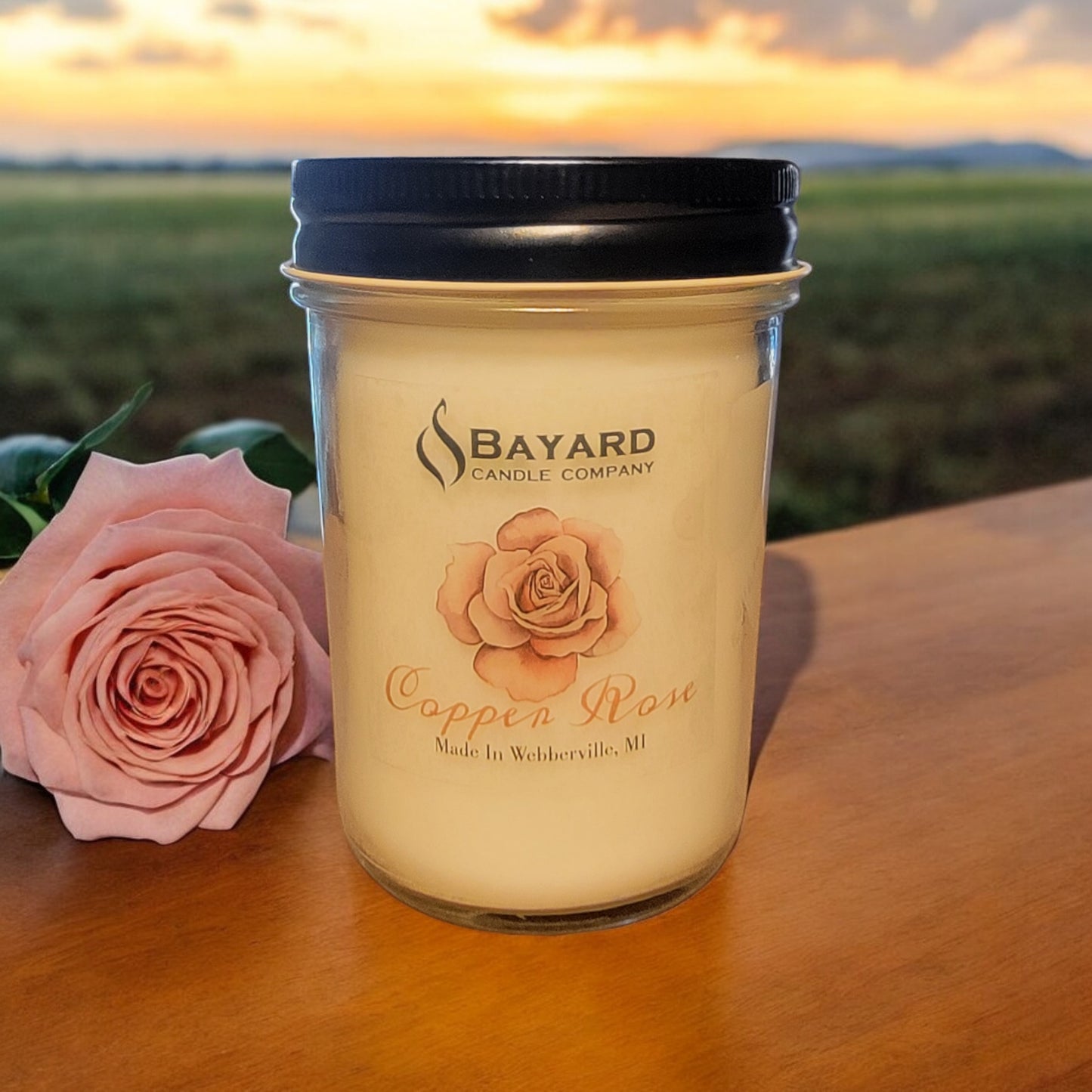 8oz Copper Rose soy candle on a farm table in a country setting